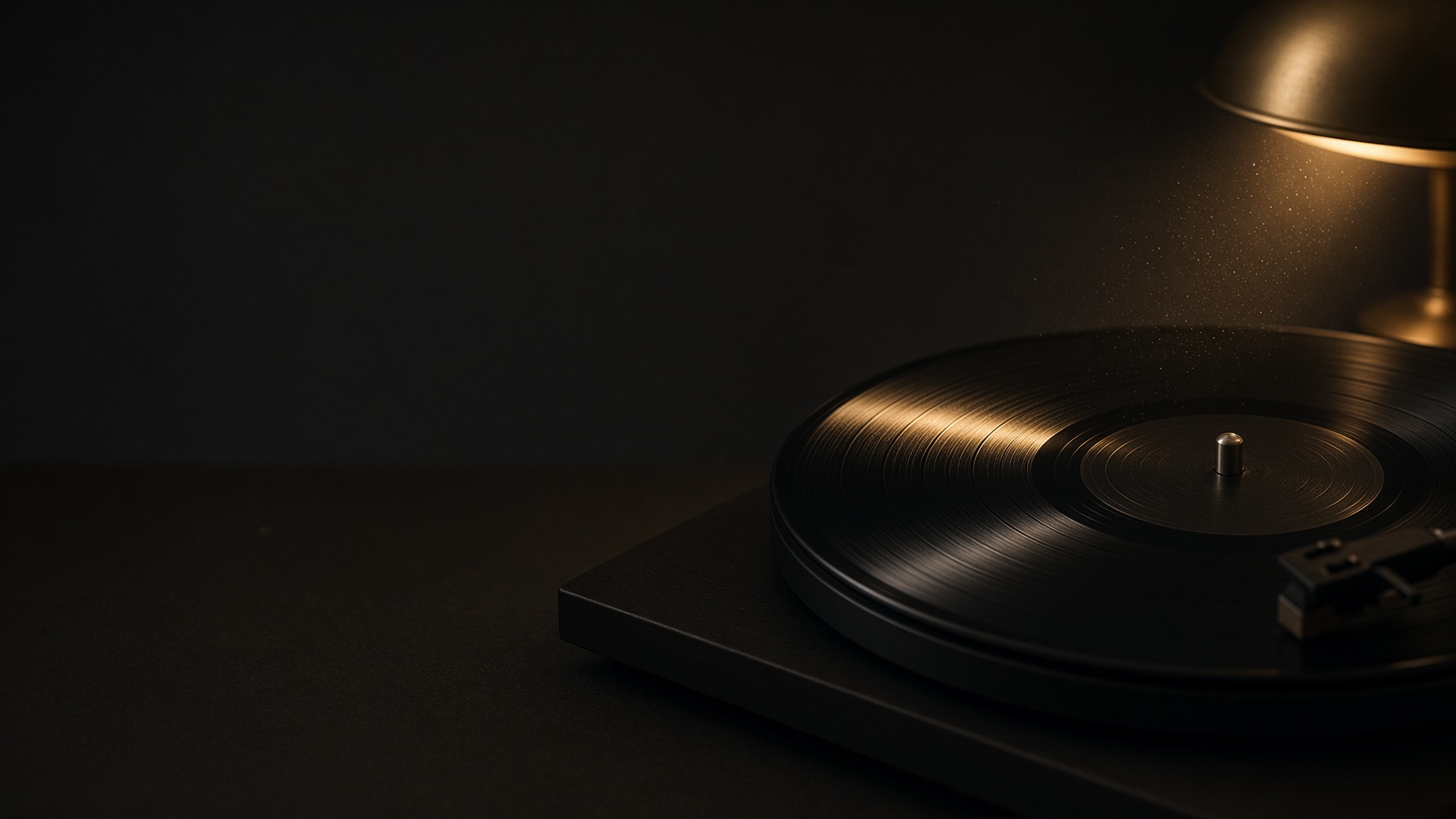 A black vinyl record in a dark room, crossed by a thin line of warm light.